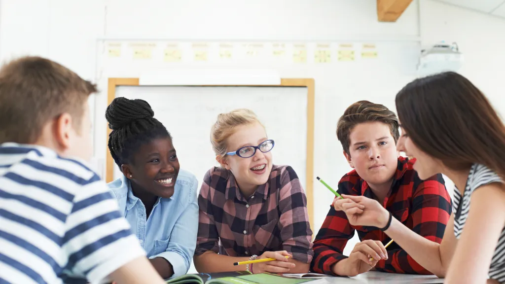 Group of teenage students collaborating on a project in a classroom.